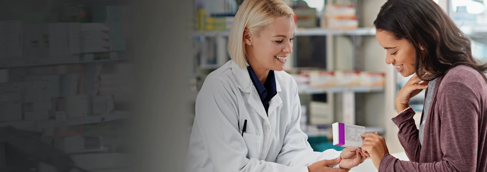 Provider showing a patient a box of medicine at a pharmacy